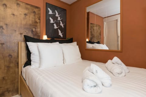 Warm and inviting bedroom with rich tones, soft linens and boutique-style details.