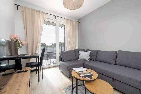 Cozy living room with a sofa bed, coffee table and access to the balcony