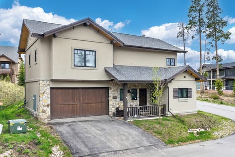 A charming mountain retreat featuring stone and stucco exterior, nestled in a scenic neighborhood with tall pines and neighboring homes visible nearby.