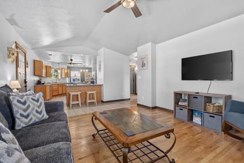 Slate-tiled coffee table sits on hardwood floors opposite a dark gray sofa in the open living area.