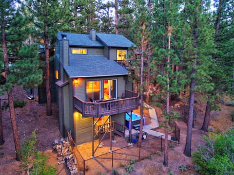 Twilight cabin exterior tucked among the pines with deck space and a private hot tub below.