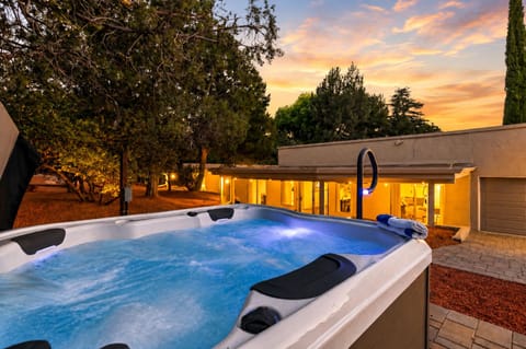 Soak in the hot tub at sunset with glowing views over the peaceful hillside setting.