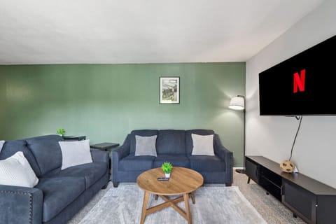 Spacious and inviting living area with comfortable seating and a smart TV, perfect for relaxing after exploring Arlington or attending events at AT&T Stadium.