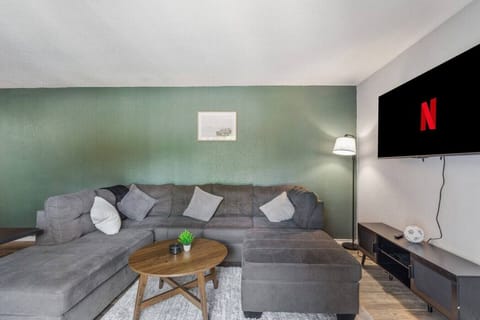Spacious and inviting living area with comfortable seating and a smart TV, perfect for relaxing after exploring Arlington or attending events at AT&T Stadium.