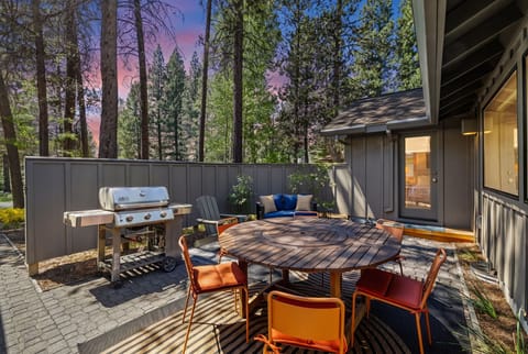 Picture yourself dining al fresco as the sky turns shades of pink and blue. Your private patio offers a gas grill for cooking, a spacious table for meals, and cozy seating surrounded by towering pines.