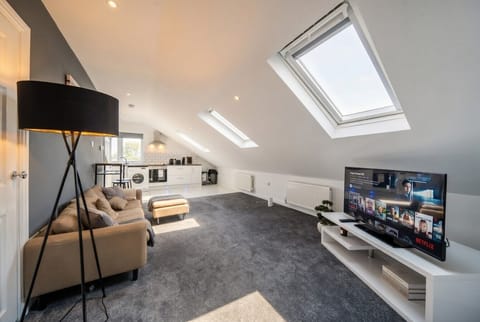 Bright open-plan living with Netflix, kitchen and skylight glow.