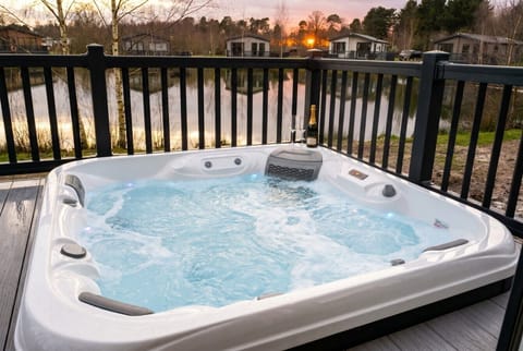 Soak in the bubbling hot tub as the sun sets over the lake.