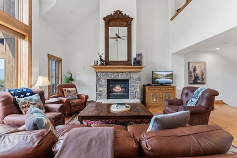 Living room with soaring ceilings, large windows, gas fireplace, and Smart Tv