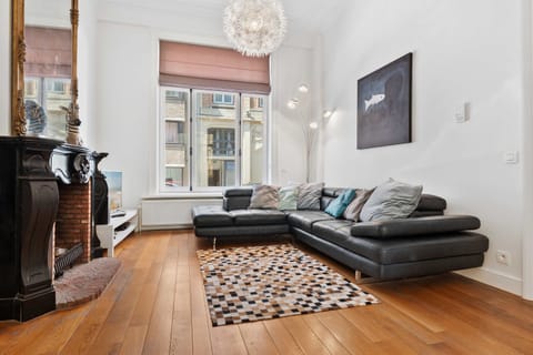 Comfortable living room with sectional sofa, smart TV and large windows – Grand Ostend townhouse with private sauna, near Oostende beach