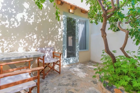 Artemis: Shaded patio with outdoor seating surrounded by greenery.