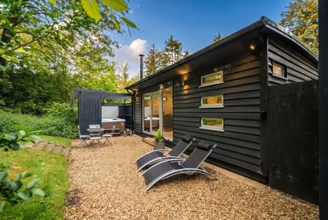 Secluded woodland lodge with private hot tub and sun loungers waiting