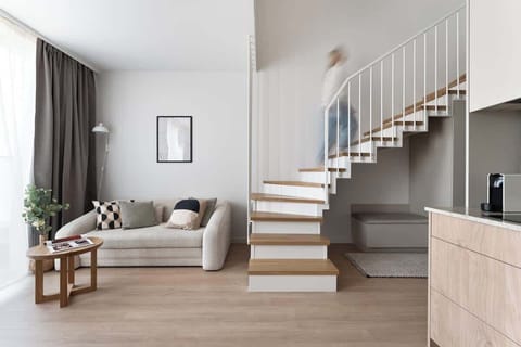 Jasny i nowocześnie urządzony salon stanowi serce apartamentu. Znajduje się tu wygodna, rozkładana sofa oraz stolik kawowy, tworzące przyjemną strefę wypoczynkową. Naprzeciwko umieszczono telewizor z kanałami kablowymi i funkcją Smart TV.