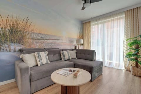 Salon stanowi serce apartamentu i oferuje wygodną, rozkładaną sofę, która może pełnić funkcję dodatkowego miejsca do spania. Naprzeciwko znajduje się telewizor z dostępem do kanałów kablowych.