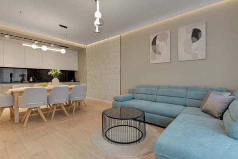 W salonie znajduje się rozkładana sofa stanowiąca dodatkowe miejsce do spania oraz telewizor z funkcją Smart TV, który umila chwile relaksu po dniu pełnym wrażeń.