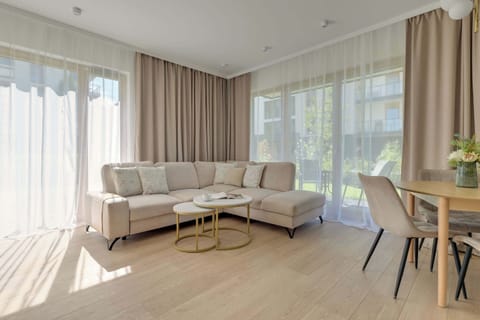 Przestronny salon stanowi centralną część apartamentu. Znajduje się tu wygodna, rozkładana kanapa, która może pełnić funkcję dodatkowego miejsca do spania. Obok znajduje się telewizor z kanałami kablowymi oraz funkcją Smart TV.