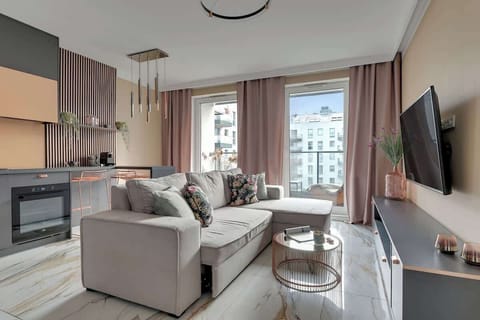 Przytulny salon z rozkładaną sofą stanowi idealne miejsce do relaksu – naprzeciw znajduje się telewizor z kanałami kablowymi i funkcją Smart TV.
