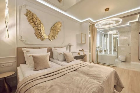 Eleganckie studio łączy luksus z komfortem. Złote detale i lustro nad łóżkiem podkreślają stylowy design, a beżowo-złota kolorystyka sprzyja relaksowi. Dla wygody gości przygotowano minibar.