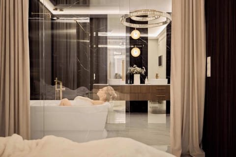 Najbardziej wyjątkowym elementem apartamentu jest luksusowa strefa kąpielowa z wolnostojącą wanną z funkcją hydromasażu, która zapewnia wyjątkowy komfort i atmosferę prywatnego SPA. 