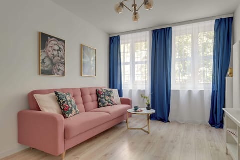 W salonie znajduje się wygodna, rozkładana sofa z funkcją spania, stolik kawowy oraz telewizor z funkcją Smart TV.