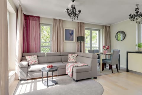 W salonie znajduje się duża, rozkładana sofa, która może pełnić funkcję dodatkowego miejsca do spania. Naprzeciwko ustawiony jest telewizor z dostępem do kanałów kablowych oraz funkcją Smart TV.