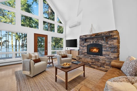 Majestic stone fireplace anchors the living room, framed by soaring vaulted ceilings and panoramic natural vistas.