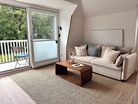 Wohnzimmer mit Sofa und Balkon. 