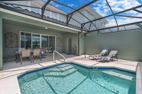 Relax by the private pool with lounge chairs and a shaded dining area in this modern outdoor space.