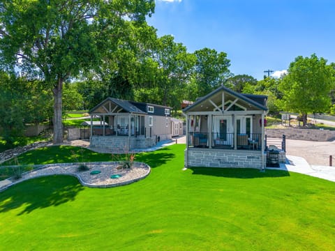 Two modern tiny homes side by side on a sprawling green lawn