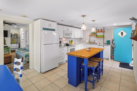 Bright coastal kitchen with island seating and colorful design touches