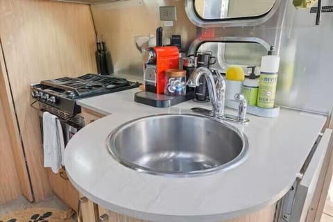 Stylish compact kitchen with gas range, coffee station, and large sink