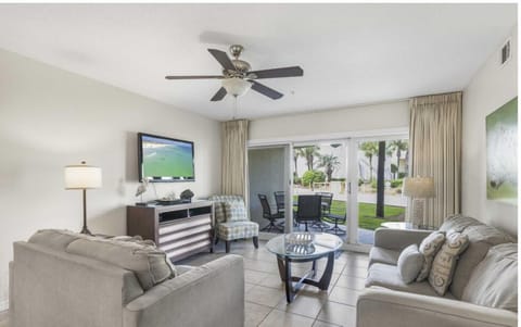 Relax in the spacious living room with comfortable seating and a large Smart TV after a day at the beach.