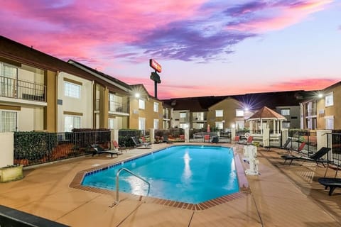 Relax poolside at sunset with calm lights and warm skies.