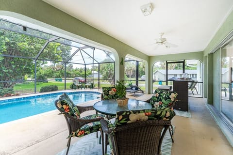 Spacious screened lanai with a private heated pool, outdoor dining, comfortable lounge seating, and seamless indoor-outdoor living—perfect for relaxing, entertaining, and enjoying your Port Charlotte vacation rental year-round.