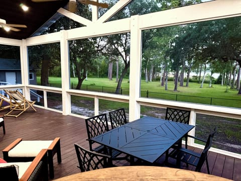Spacious screened porch with dining area and serene wooded yard views