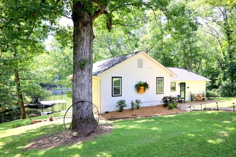 Side exterior view of the main home with lake access, wooded surroundings, and peaceful outdoor setting