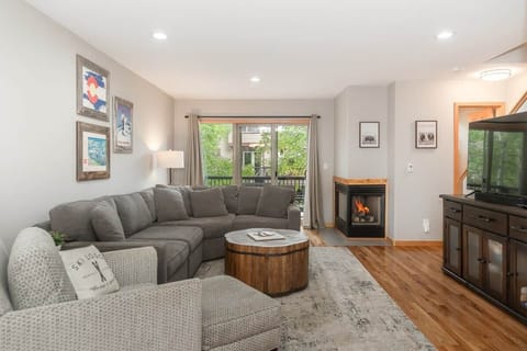 Cozy living room with sectional sofa, fireplace, and deck access.