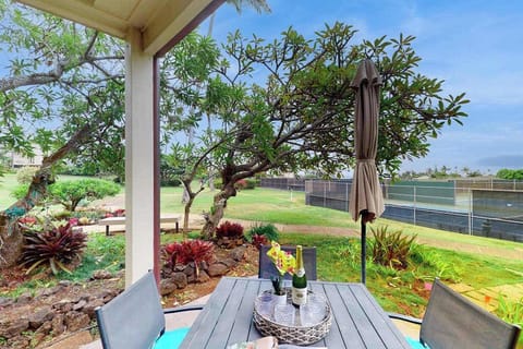 Covered outdoor dining area surrounded by lush tropical landscaping
