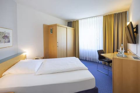 Unwind in a bright room with cozy bed and workspace.