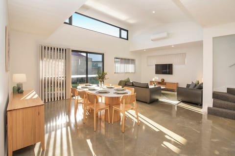 Bright open-plan living with soaring ceilings, dining for 6, and sunny lounge