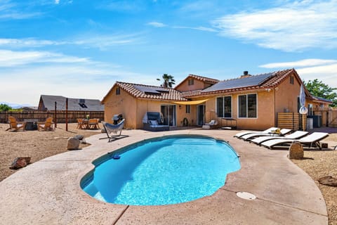 A refreshing, custom-shaped swimming pool takes center stage in this desert-oasis backyard.