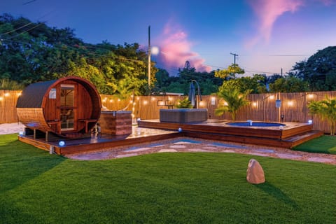 Twilight view of the backyard with sauna and wellness deck.