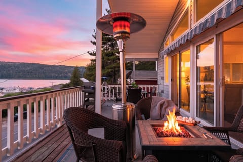 Sunset balcony with lake views, cozy fire pit seating, and warm evening ambiance.