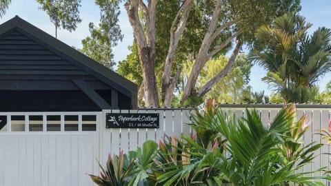Paperbark Cottage entrance, framed by lush tropical gardens and a majestic paperbark tree, offering a warm welcome to this private Port Douglas retreat