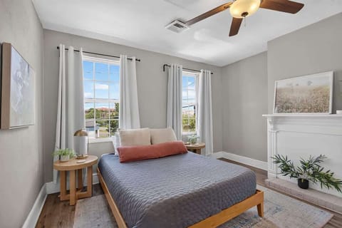 Bright and cozy bedroom with a fireplace, soft natural light, neutral décor, and peaceful city views.