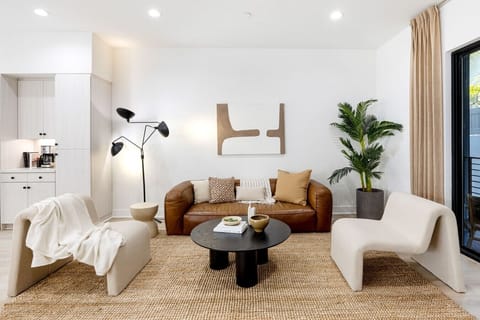 Warm, stylish living room with a leather sofa and cozy accent chair, a great spot to unwind after a day out.