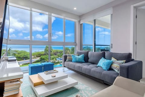 Sink into the plush sofa and soak in stunning turquoise ocean views framed by floor-to-ceiling windows. Your tranquil escape awaits in this bright, beautifully designed living space.