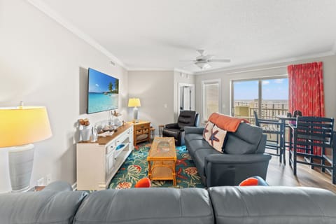 Living room are with plenty of seating and large TV with balcony access