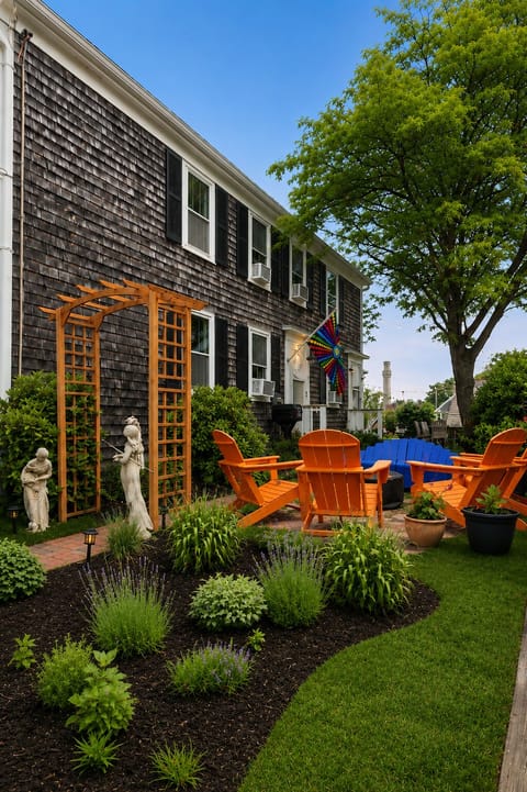 Charming garden patio with fire pit, Adirondack chairs, and lush landscaping