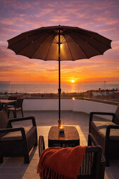 Ocean-view sunset terrace with cozy lounge seating and rooftop ambiance