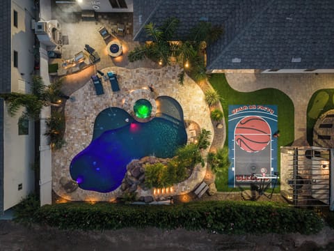 Resort-style backyard with lit pool, spa, fire pit & private basketball court